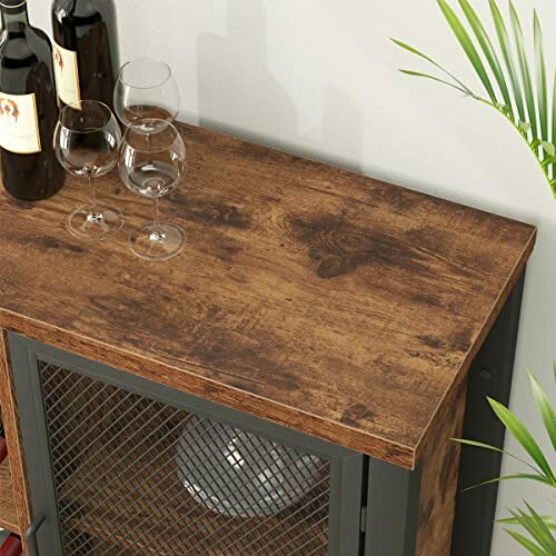 Rustic wooden tabletop with wine bottles and glasses.